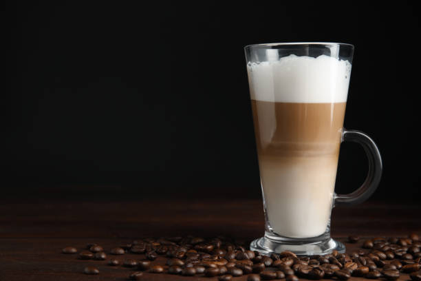 istock Delicious latte macchiato and coffee beans on wooden table, space for text 1436981606