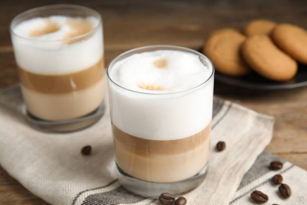istock Delicious latte macchiato and coffee beans on wooden table 1436982781