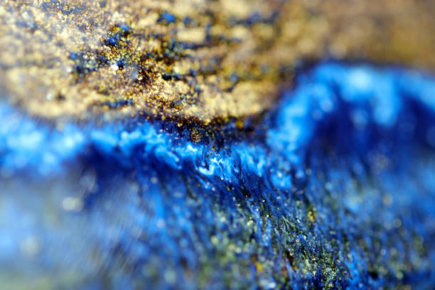 Beautiful pottery base with a unique glaze pattern that shines bright cobalt blue and gold. Close up macro texture photograph.