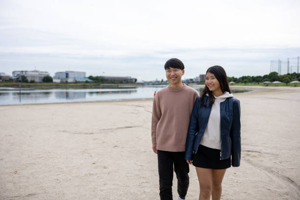 istock Young couple walking in white sand beach 1436985153