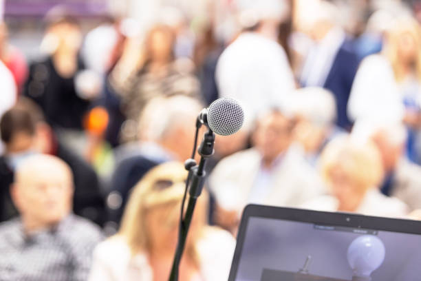 istock Public speaking event concept, microphone in the focus, blurred people in the background 1436985503