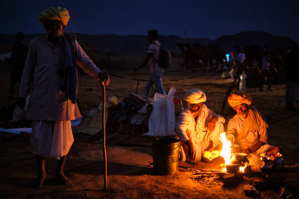 プシュカルラクダフェアプシュカルメラでのインドの男性とラクダ - india campfire desert camel ストックフォトと画像