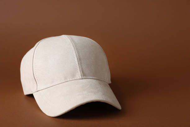 istock Stylish beige baseball cap on brown background. Space for text 1436989455