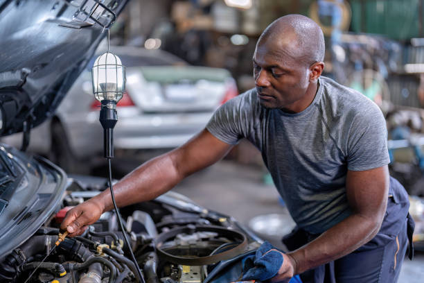 istock Mechanical guy at car repair shop stand pulling engine oil dipstick 1436998192