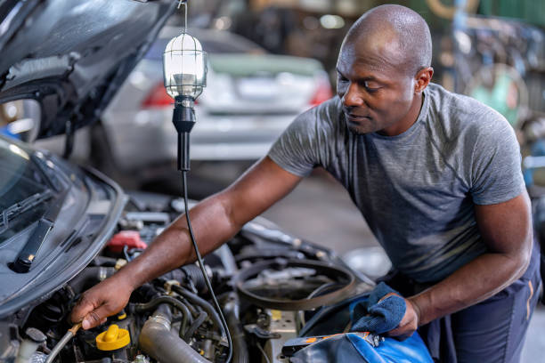 istock Mechanical guy at car repair shop stand pulling engine oil dipstick 1436998193