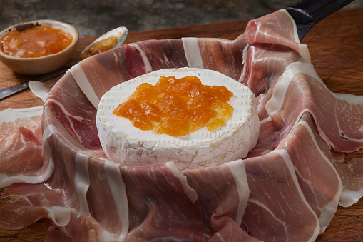 Preparing Prosciutto Wrapped Brie with Apricot Preserves