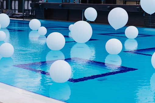 white balloons over the pool. original decoration of the territory of a hotel or country house for a holiday or party.