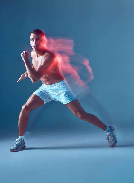 istock Fit guy dancing zumba. Young man dancing in white shorts with bare torso on blue background. 1437011304