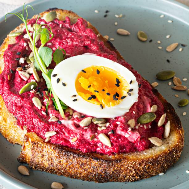 istock Whole grain toast with beetroot hummus, seeds, egg and microgreens (sprouted pea sprouts) on a light gray background. The concept of healthy eating.. 1437011587