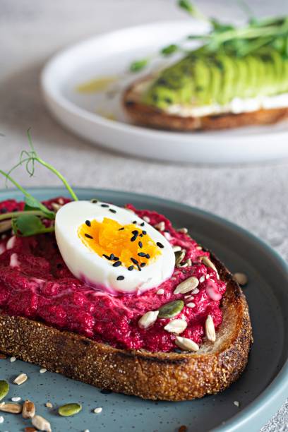 istock Whole grain toast with cream cheese, avocado, beetroot hummus, seeds, egg and microgreens (sprouted pea sprouts) on a light gray background. Healthy food concept. 1437011647
