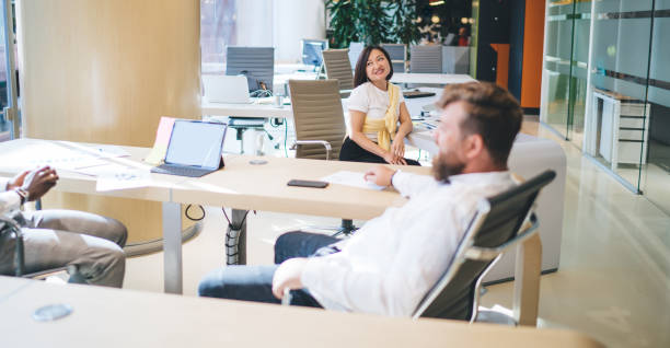 Young male and female coworkers chatting in modern office on a break