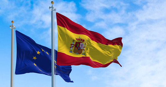 the flags of Spain and the European Union waving in the wind on a sunny day. Democracy and politics. European country.