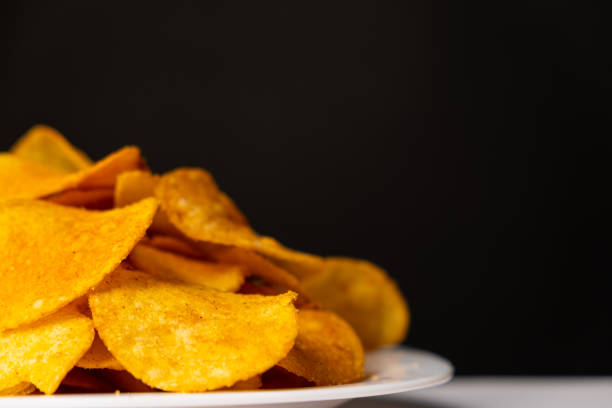 istock Delicious crispy potato chips with spices on a black background, place for text 1437015459