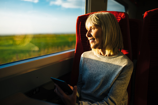 Woman on a train reading from her digital tablet.