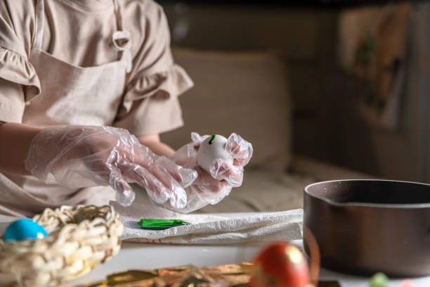 cute girl at home in the kitchen dyes eggs for Easter
