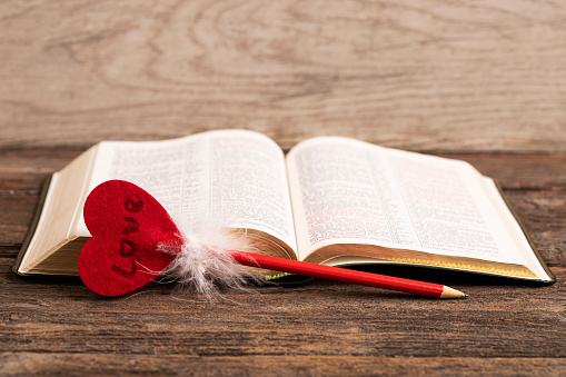 Bible and pencil with heart