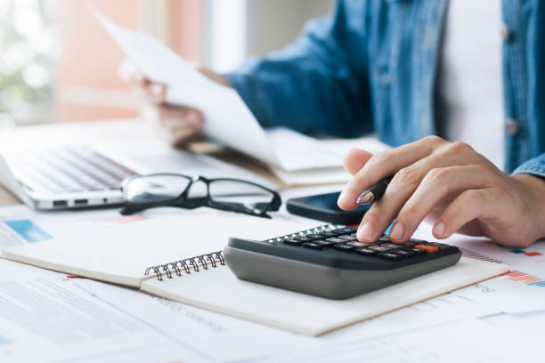 fotografii de stoc, fotografii și imagini scutite de redevențe cu investitorii calculează profiturile și costurile cu calculatoare, analiza diagramei de creștere și de investiții, planificarea afacerilor și strategii pentru a maximiza profiturile din vânzări. plan de afaceri pe termen lung. - calculator de buzunar
