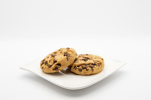 Two american cookies on a small plate with white background