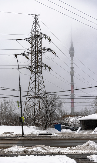 Ostankino Tower and Electric energy transmission line on a foggy day in winter.