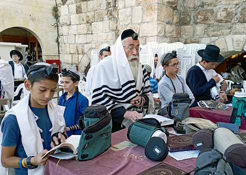 An orthodox jewish rabbi praying together with his students during the early \