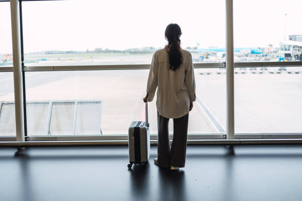istock Latin woman with suitcase is going waiting for the next flight 1437035983
