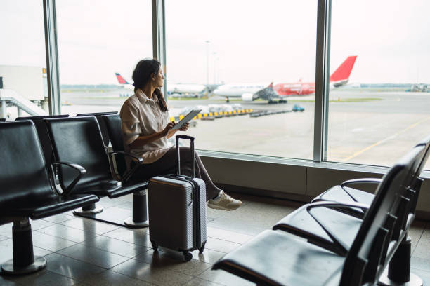 Young female passenger waiting for flight at airport lounge stock photo