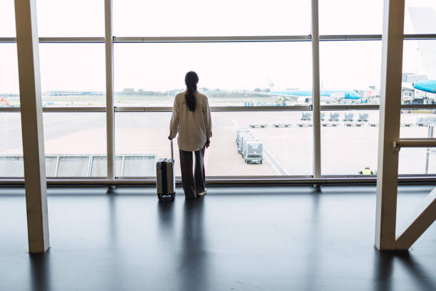 istock Woman with suitcase is going waiting for the next flight 1437036848