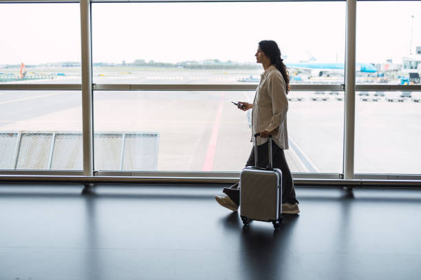 istock Latin woman with suitcase is going to board on the next flight 1437036930
