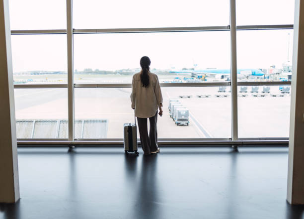 istock Latin woman with suitcase is going waiting for the next flight 1437037203