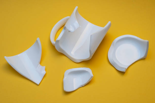 istock Splinters of the broken mug on a yellow background. 1437038455