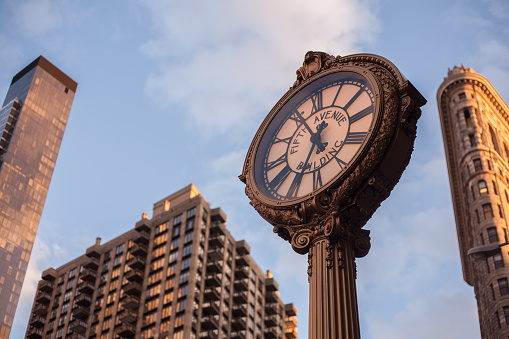 New York City, USA - March 30, 2015 : Clock and Flatiron building at midtown
