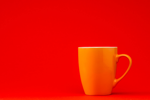 Orange cup on red background