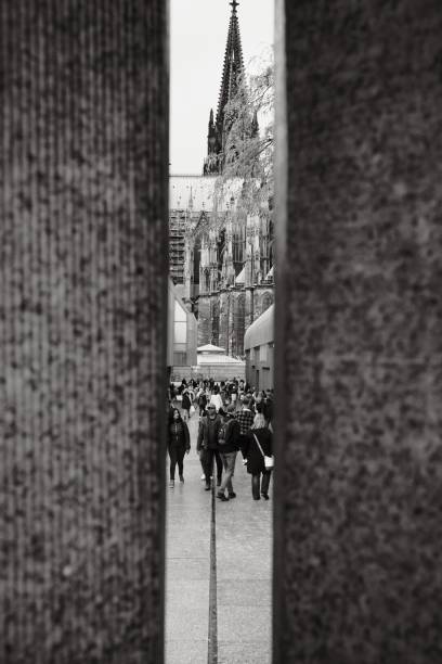 Koeln, Germany – October 15, 2022: A greyscale shot of the Cologne Cathedral between two stone columns in Cologne, Germany