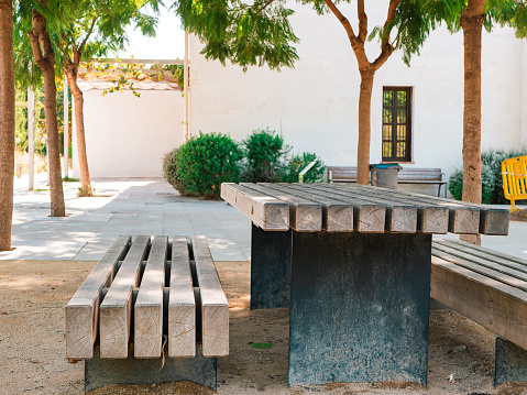 A wooden bench and a table standing in the courtyard. Nice place to rest and eat