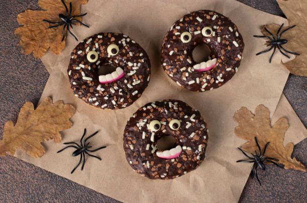 istock Halloween festive donuts with eyes and teeth on brown background 1437044975