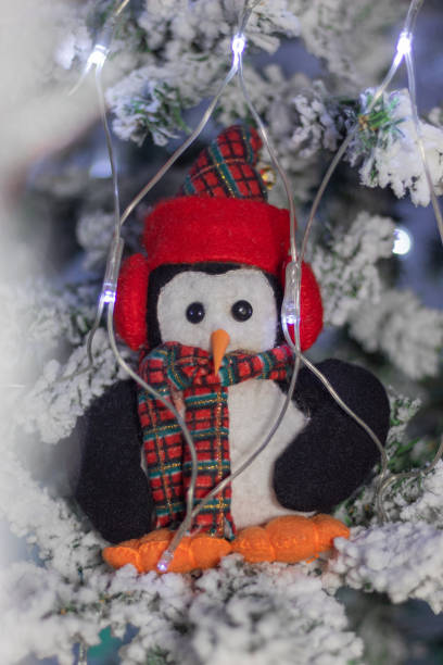 istock Christmas cute penguin doll on a snowy christmas tree 1437045841