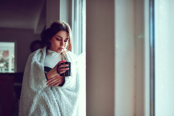 istock Cute Female Warming Up With Cup Of Tea During Autumn 1437047188