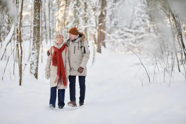 Photo of Loving Couple Walking in Winter Forest