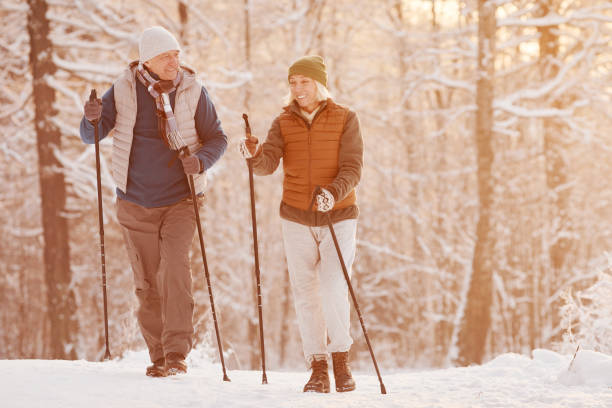 istock Senior Couple Walking With Poles in Winter 1437052371