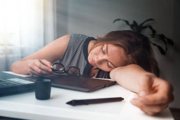 istock Young woman sleeping in the workplace. Fatigue and overload in office work. Morning light 1437053459