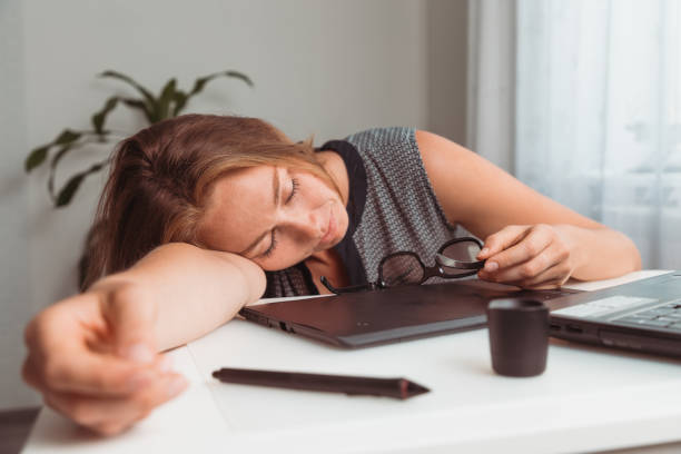 Young woman sleeping in the workplace. Fatigue and overload in office work