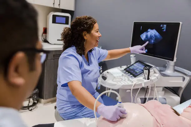 Photo of Female sonographer points to the computer screen