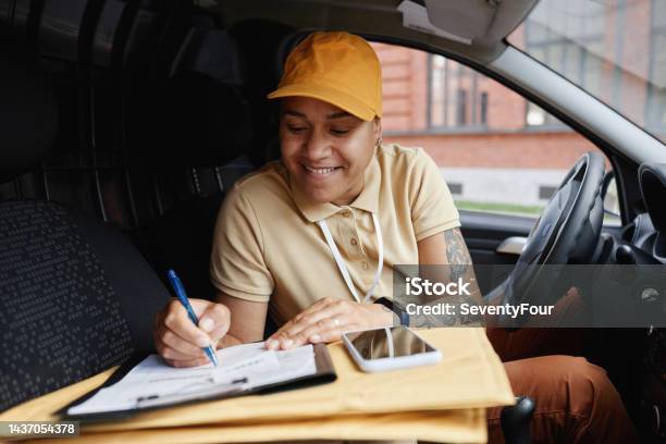 Delivery Worker Signing Forms Stock Photo - Download Image Now - Driving, Delivering, Females