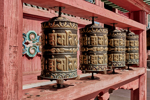 Close-up prayer drums, khurde. Attribute used in Buddhist rituals. Ivolginsky Datsan, Buddhist monastery, Buryatia, Russia. Text in Sanskrit- syllables of mantra-om mani padme hum