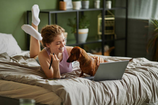 istock Happy girl using laptop in bed 1437056188