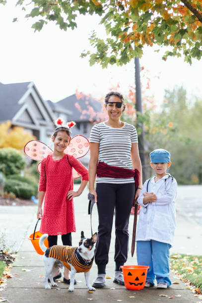 istock Young Family Trick Or Treating Together And Posing For Camera 1437056713
