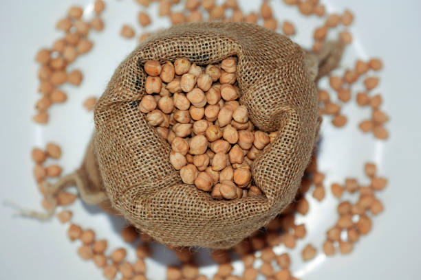 Chickpeas filled in sack table top spin isolated on white background.