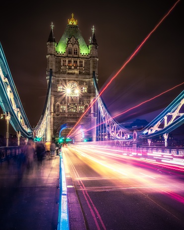 A vertical shot of long exposure cars driving over the Tower Bridge at night in London, United Kingdom