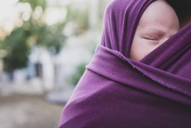 Close up sleeping baby in a sling
