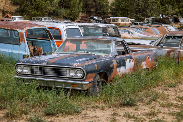 alte rostige oldtimer auf einem schrottplatz geparkt - autofriedhof stock-fotos und bilder